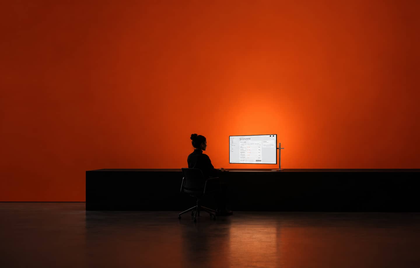 An operator reviewing the XS portfolio dashboard in an orange-lit workspace